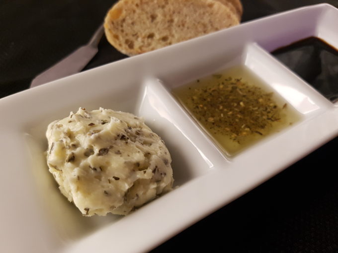 Sweet basil and garlic butter served along side herbed olive oil and balsamic vinegar, and multigrain bread