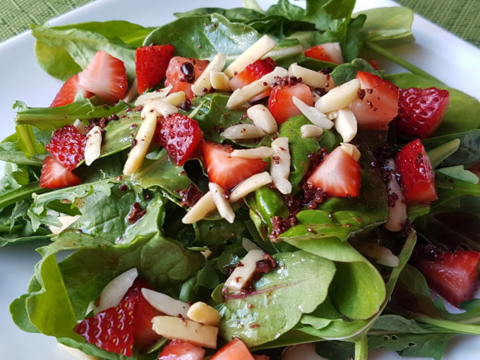 Cacao Nib Dressing Over Greens with Strawberries and Almond Slivers