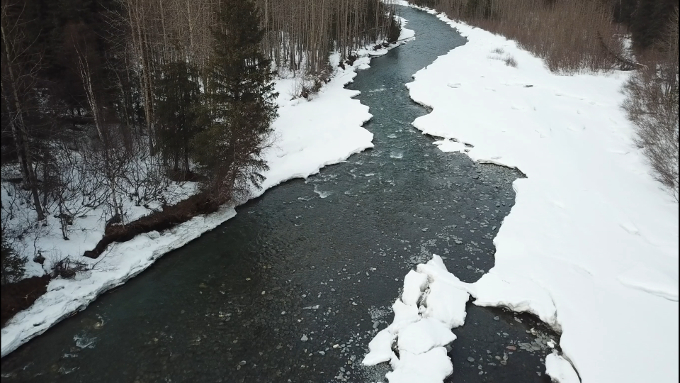 Overhead view of a partially frozen river in Alaska